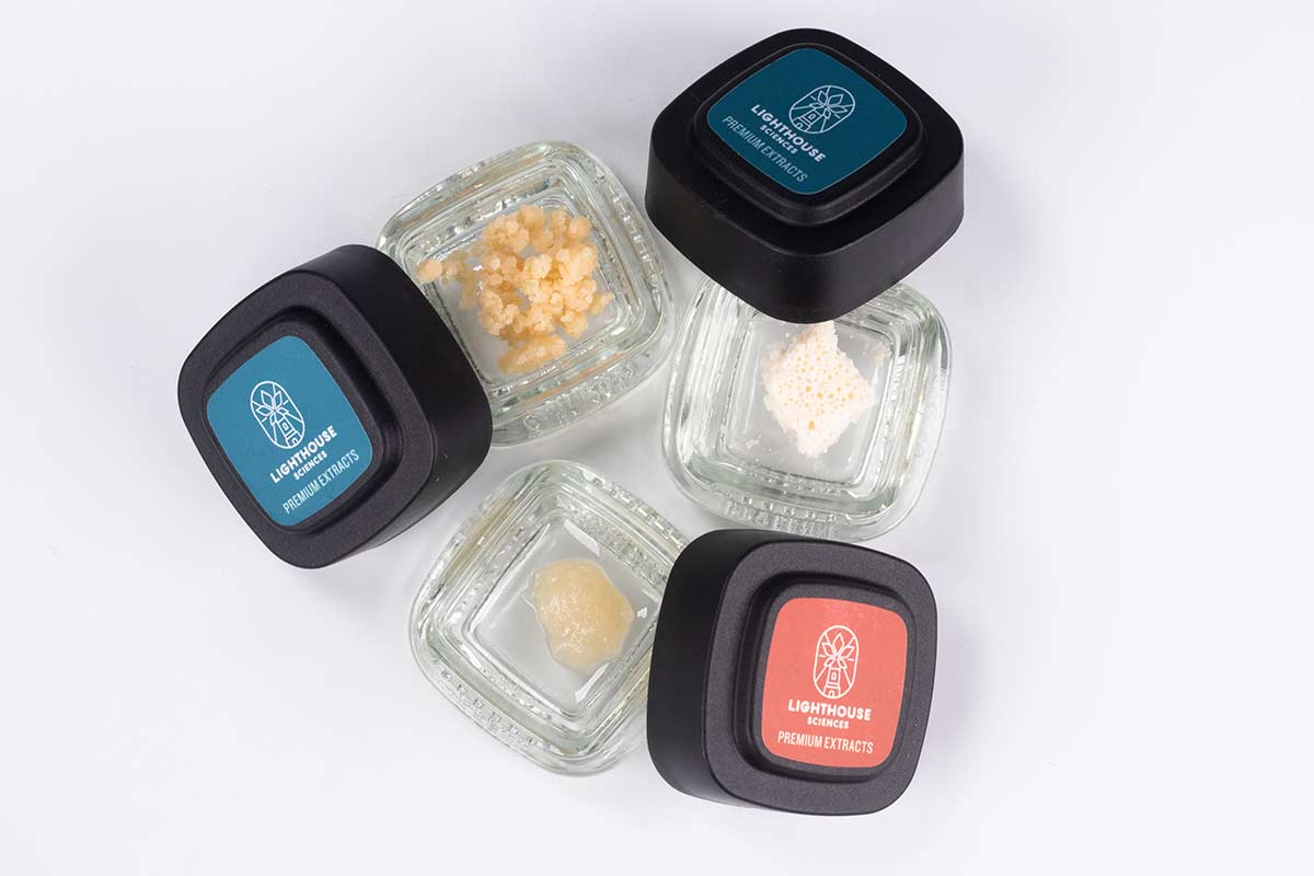 Three containers of LHS cannabis concentrates on a white background